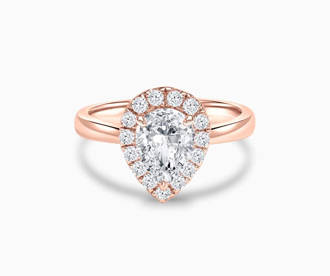 pear shaped diamond halo engagement ring set in rose gold with a tapered plain band design