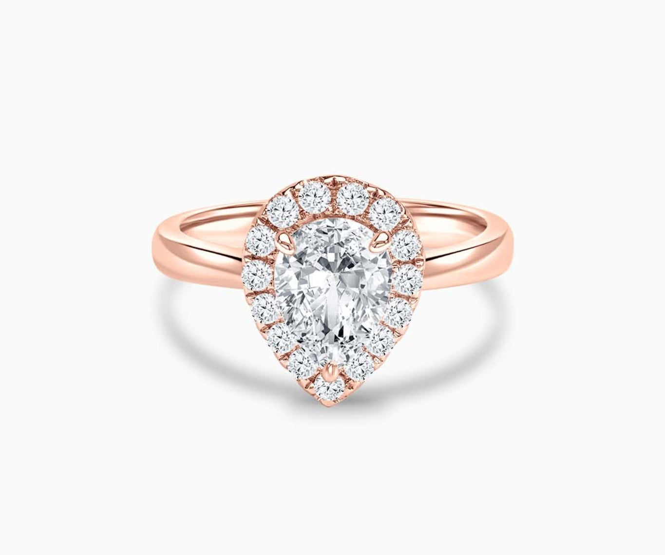 pear shaped diamond halo engagement ring set in rose gold with a straight plain band design