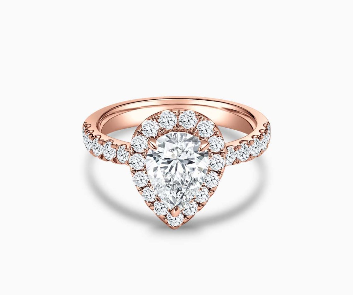 pear shaped diamond halo engagement ring set in rose gold with a tapered pave band design