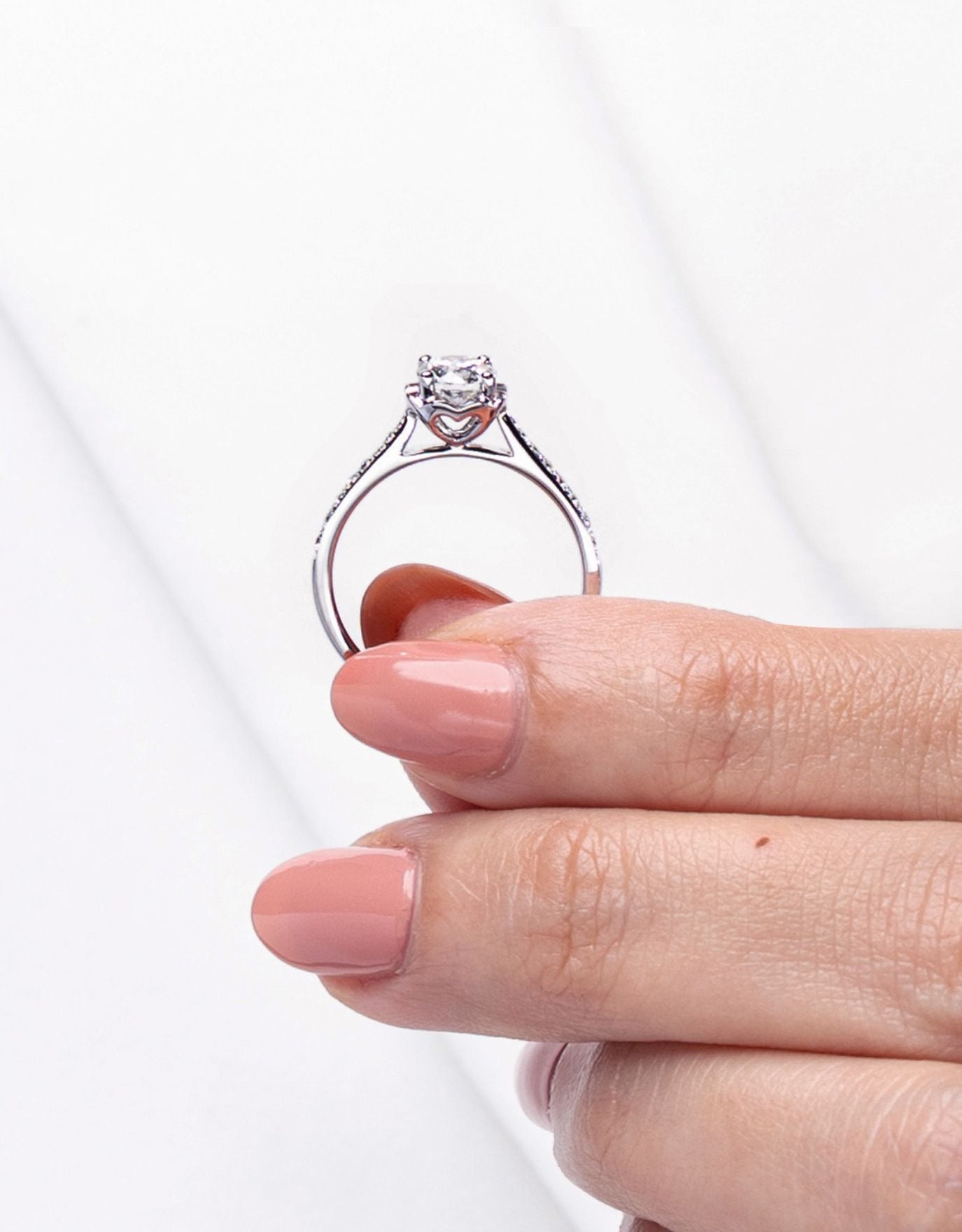 LVC a woman holding the lab grown diamond ring in white gold with a paved setting band