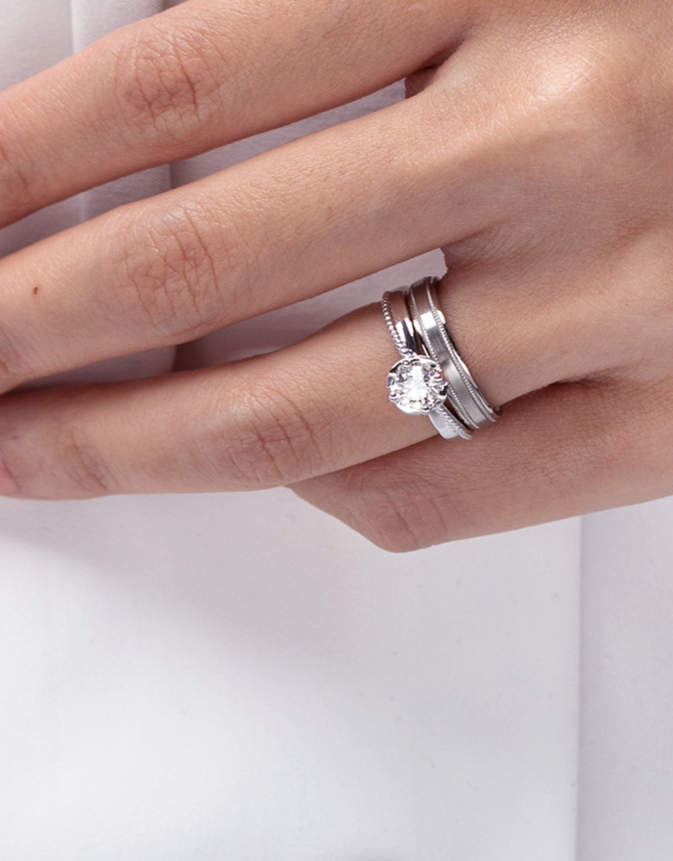 LVC a woman wearing a lab grown diamond ring with a milgrain design alongside an engagement ring