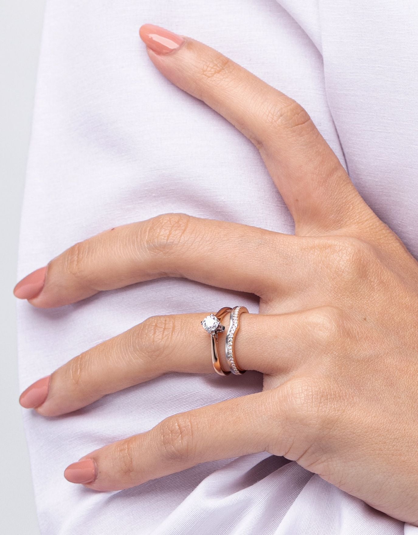 LVC wedding band in duo tones designed with a curved arc of round endless diamonds worn on finger with other ring for stackable and elegant look