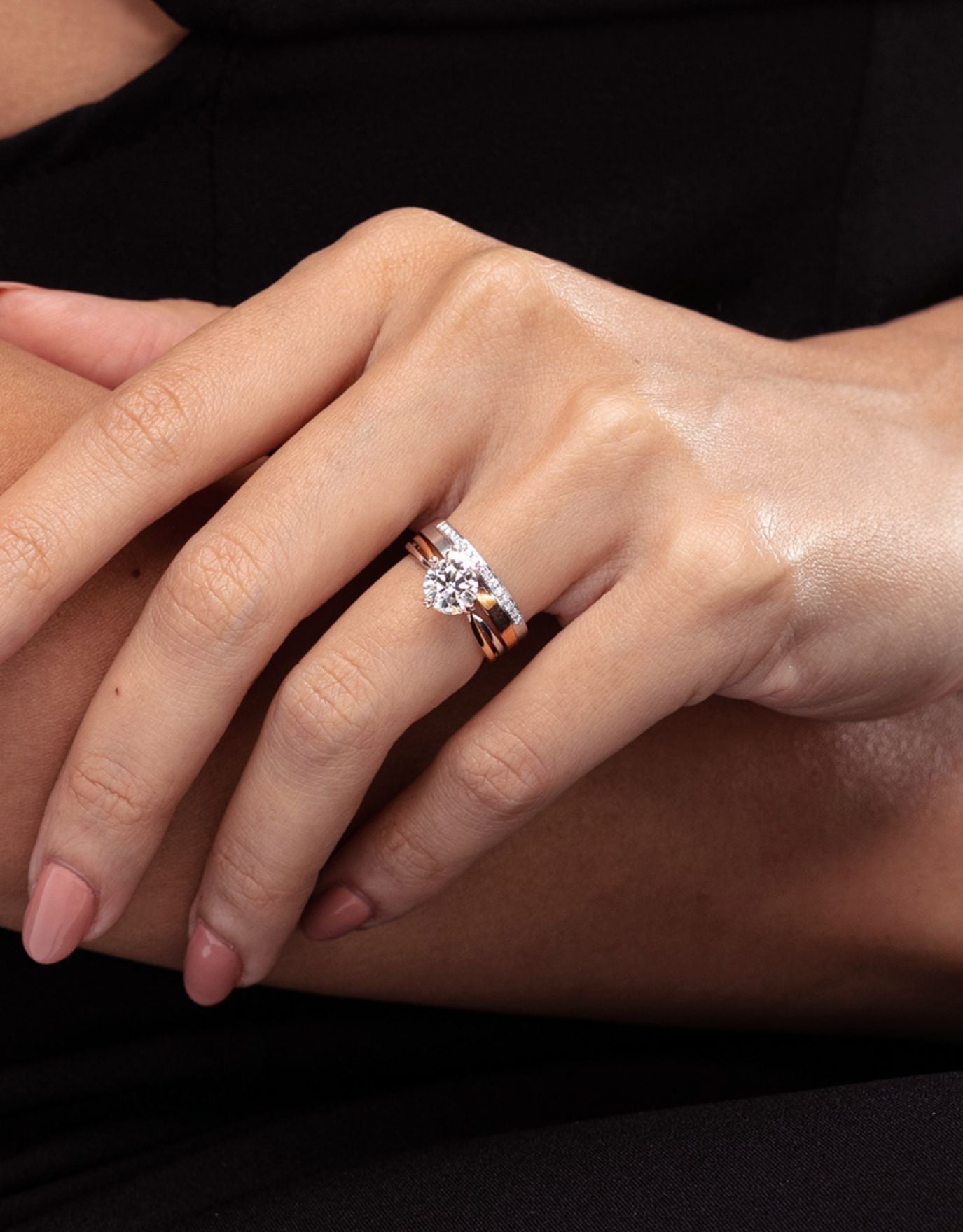 LVC wedding ring in white gold and rose gold stacked with an engagement ring on the ring finger
