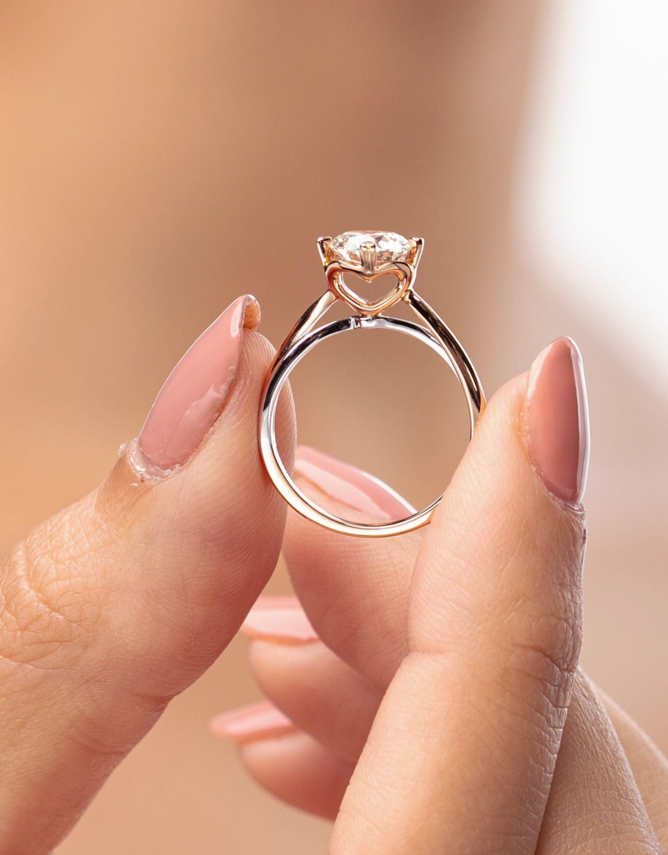 LVC a woman holding the lab grown diamond ring from the say love collection with a heart shaped cathedral setting