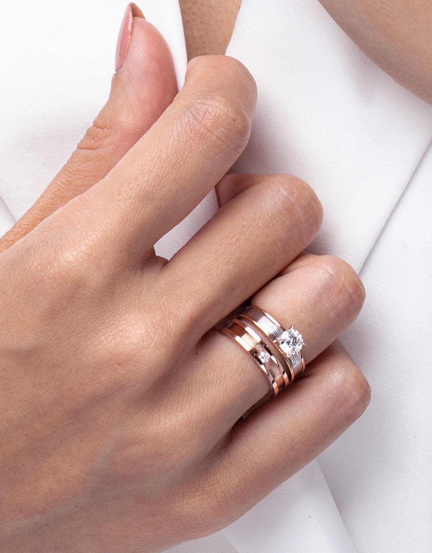 LVC two lab grown diamond ring solitaire  in rose gold with different carat diamonds worn on a woman