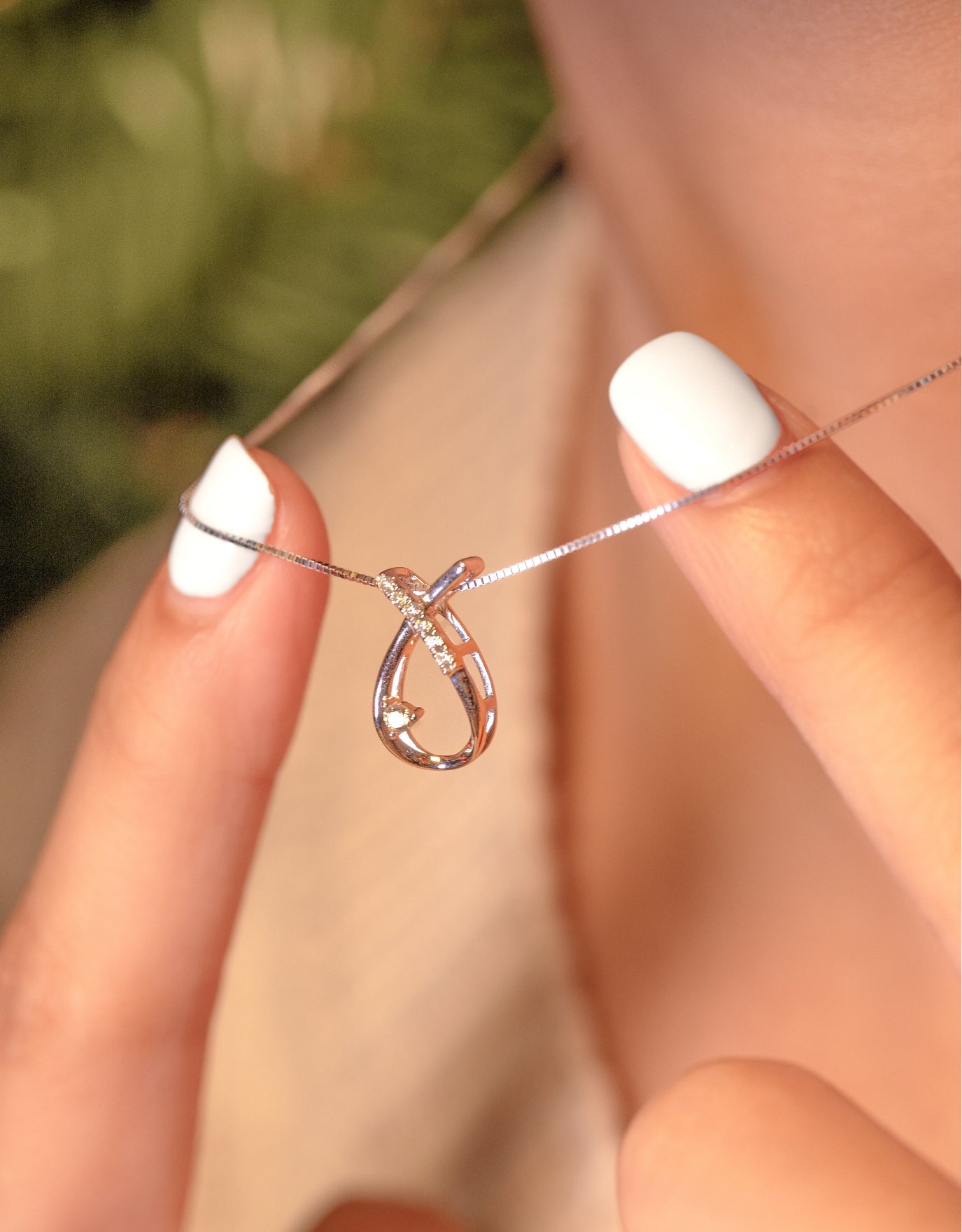 woman wearing the LVC white gold diamond necklace with the crossed horseshoe pendant design