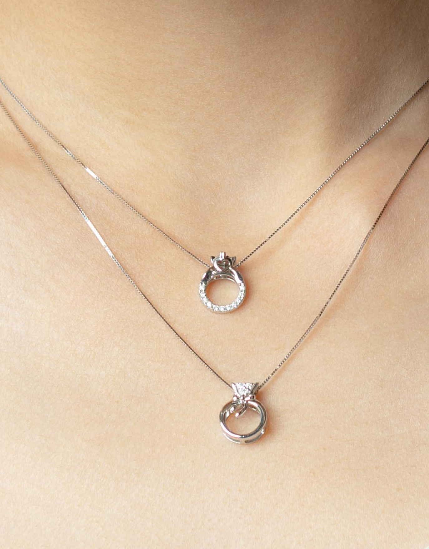 woman wearing the LVC necklace in white gold features a dainty rose gold bow tied on the mini ring pendant