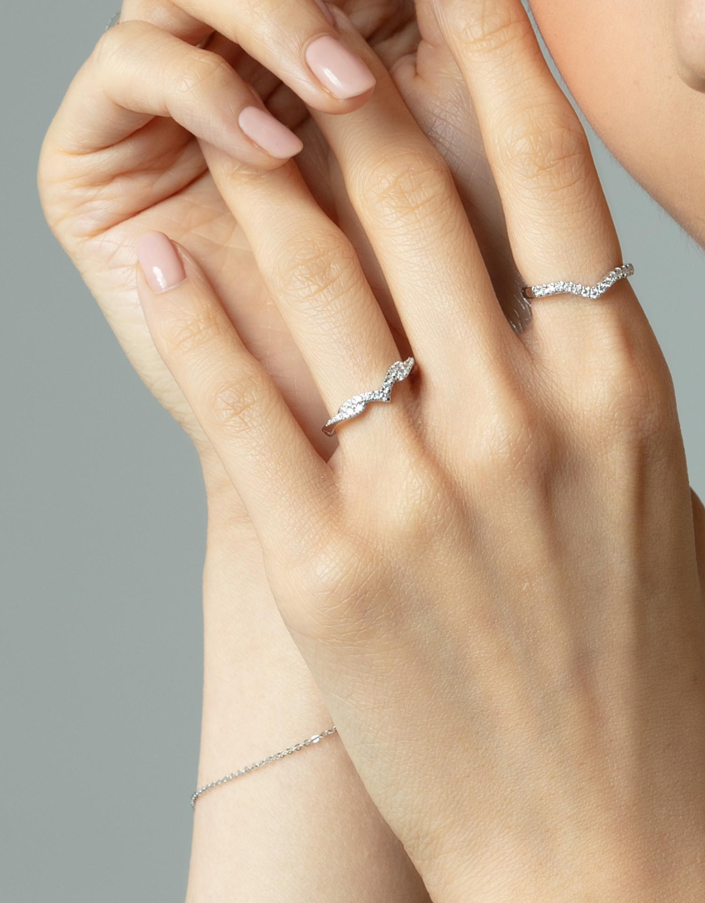 LVC wedding ring in white gold being worn on a woman's ring finger with another ring on the index finger