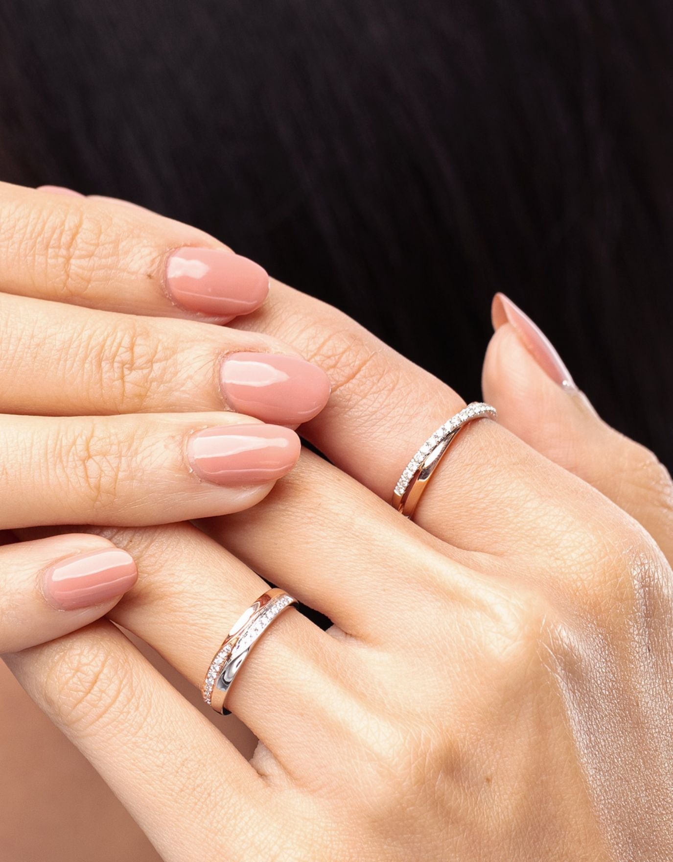 LVC woman wearing two wedding rings on her ring finger and index finger with two layers of rose gold and white gold