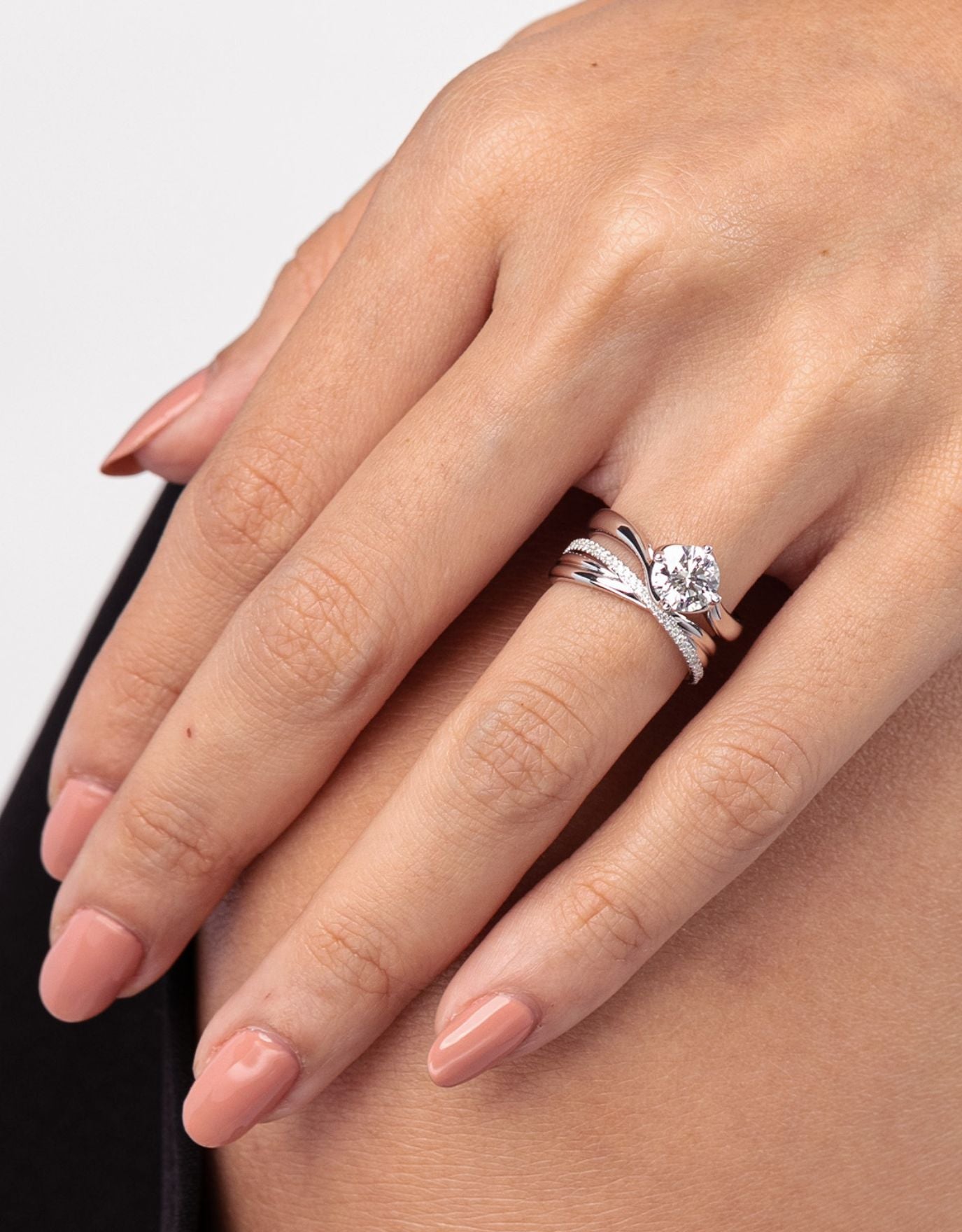 LVC wedding band in white gold designed with an intertwining of bands fitted with a row of stunning diamonds that runs across the ring worn on ring finger, stacked with another ring