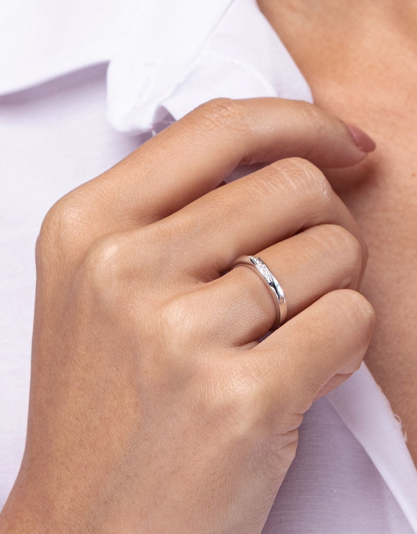 LVC wedding band designed with a leaning row of round diamonds worn on ring finger