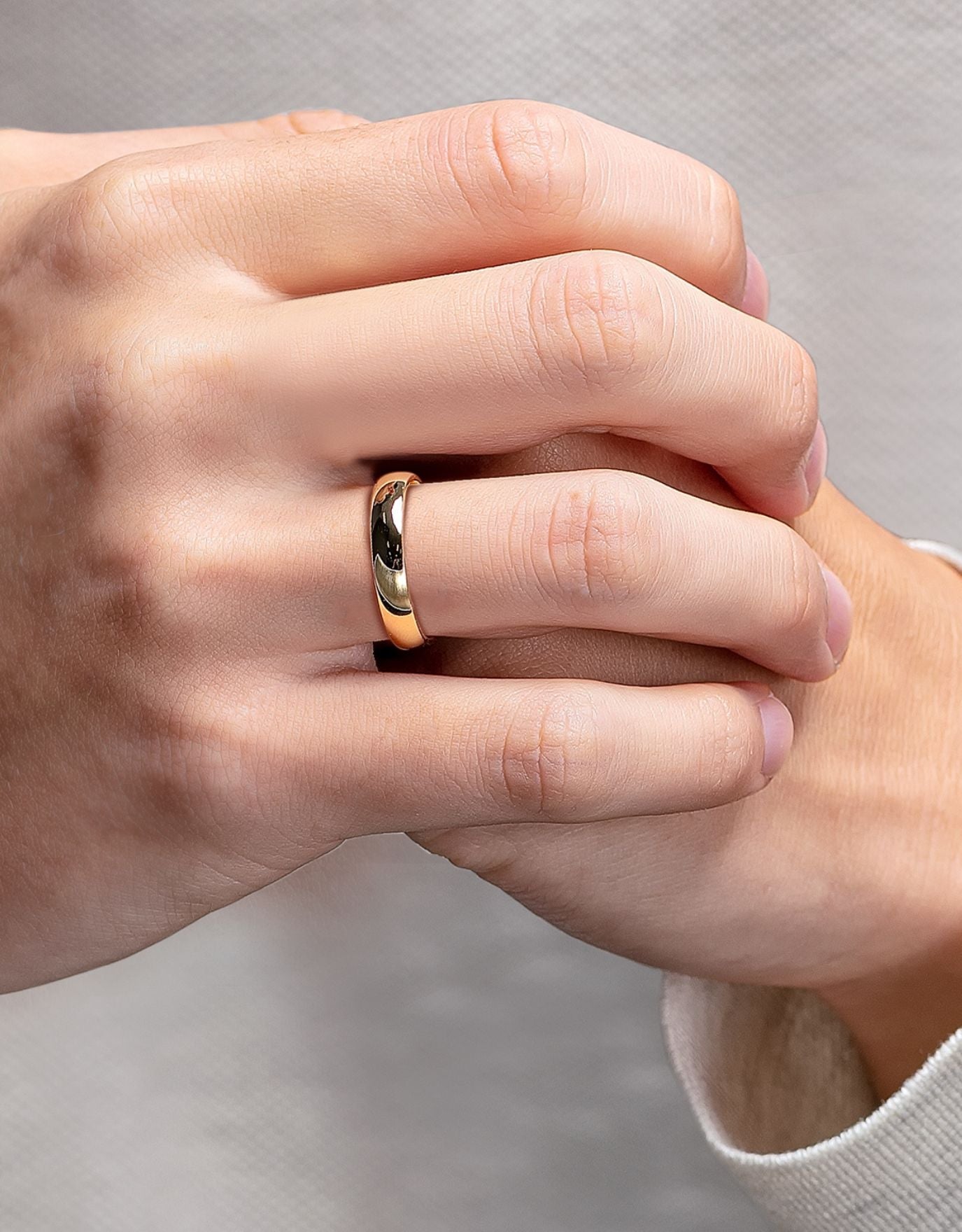 LVC men wedding band in yellow gold crafted with a glossy finish for the elegant and modern look worn on ring finger 