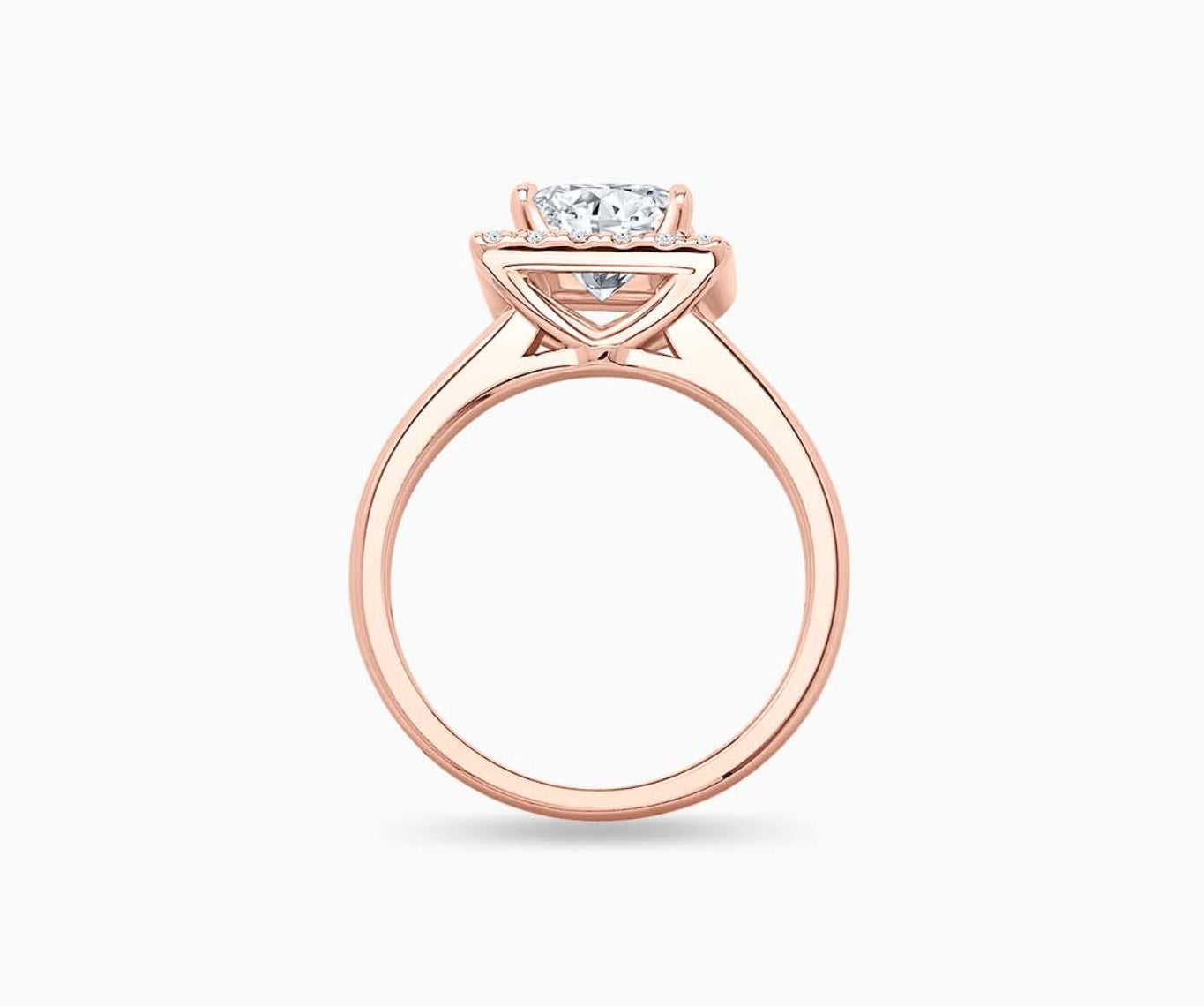 side view of princess cut diamond halo engagement ring set in rose gold with a tapered plain band design