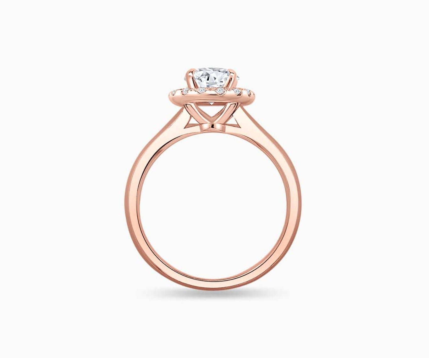 side view of an oval-cut diamond halo engagement ring set on rose gold with a straight plain band design