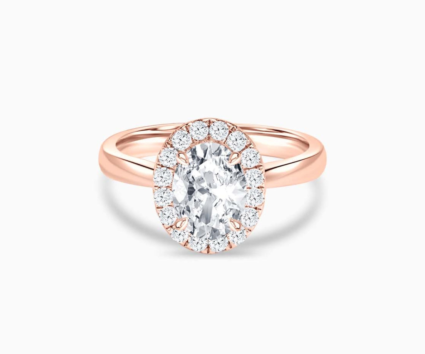 An oval-cut diamond halo engagement ring set on rose gold with a tapered plain band design