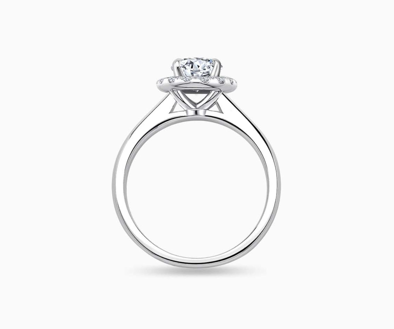 side view of oval cut diamond halo engagement ring with a tapered plain white gold band 