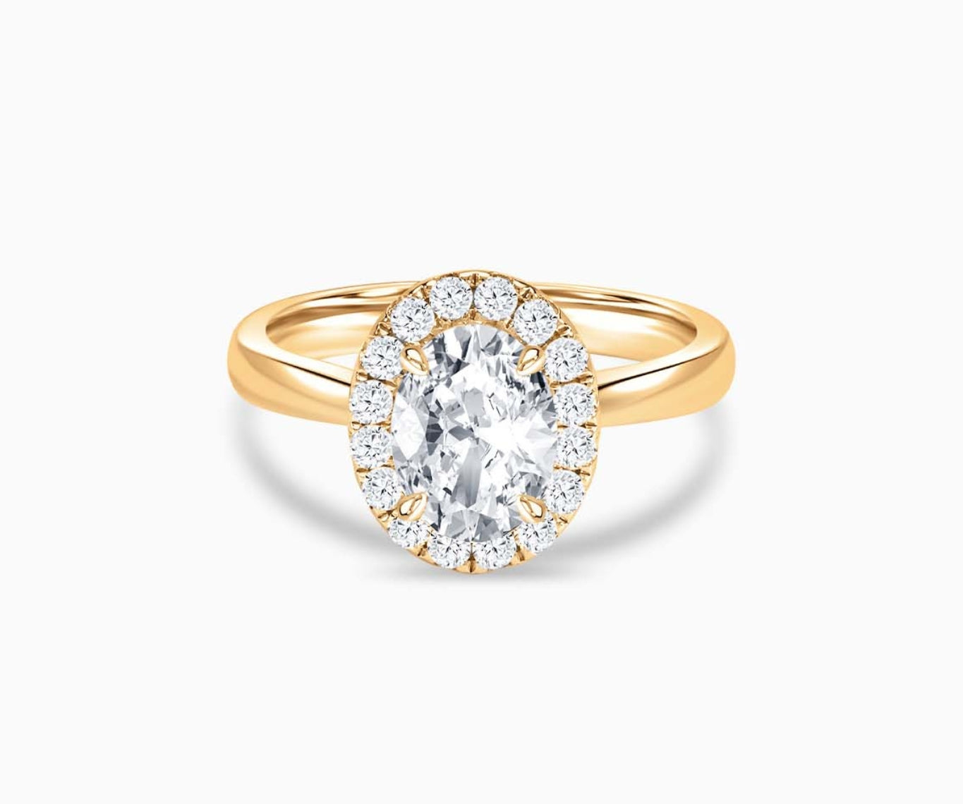 Oval cut diamond halo engagement ring set on yellow gold with a tapered plain band design