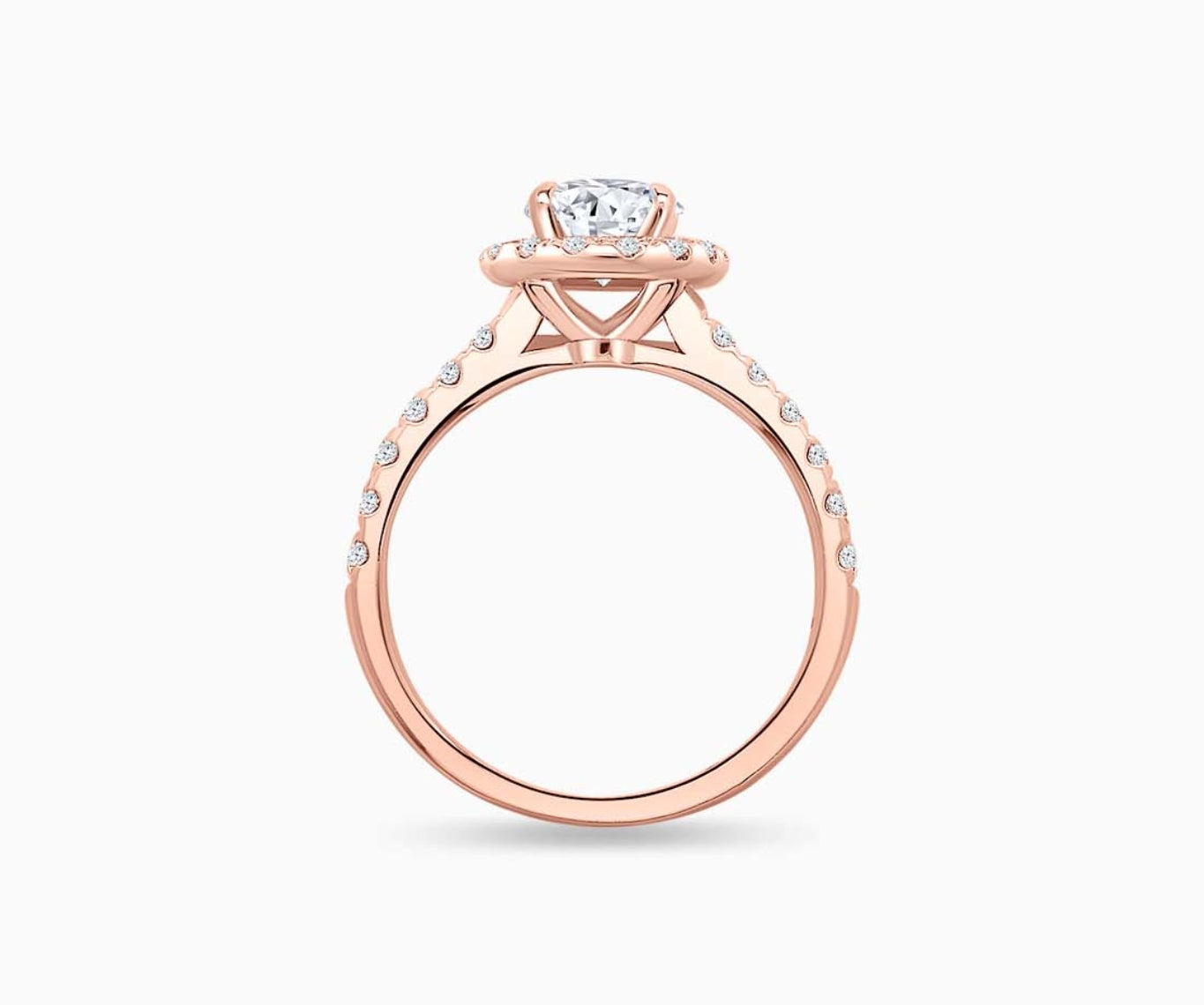 side view of An oval-cut diamond halo engagement ring set on rose gold with a tapered pave band design
