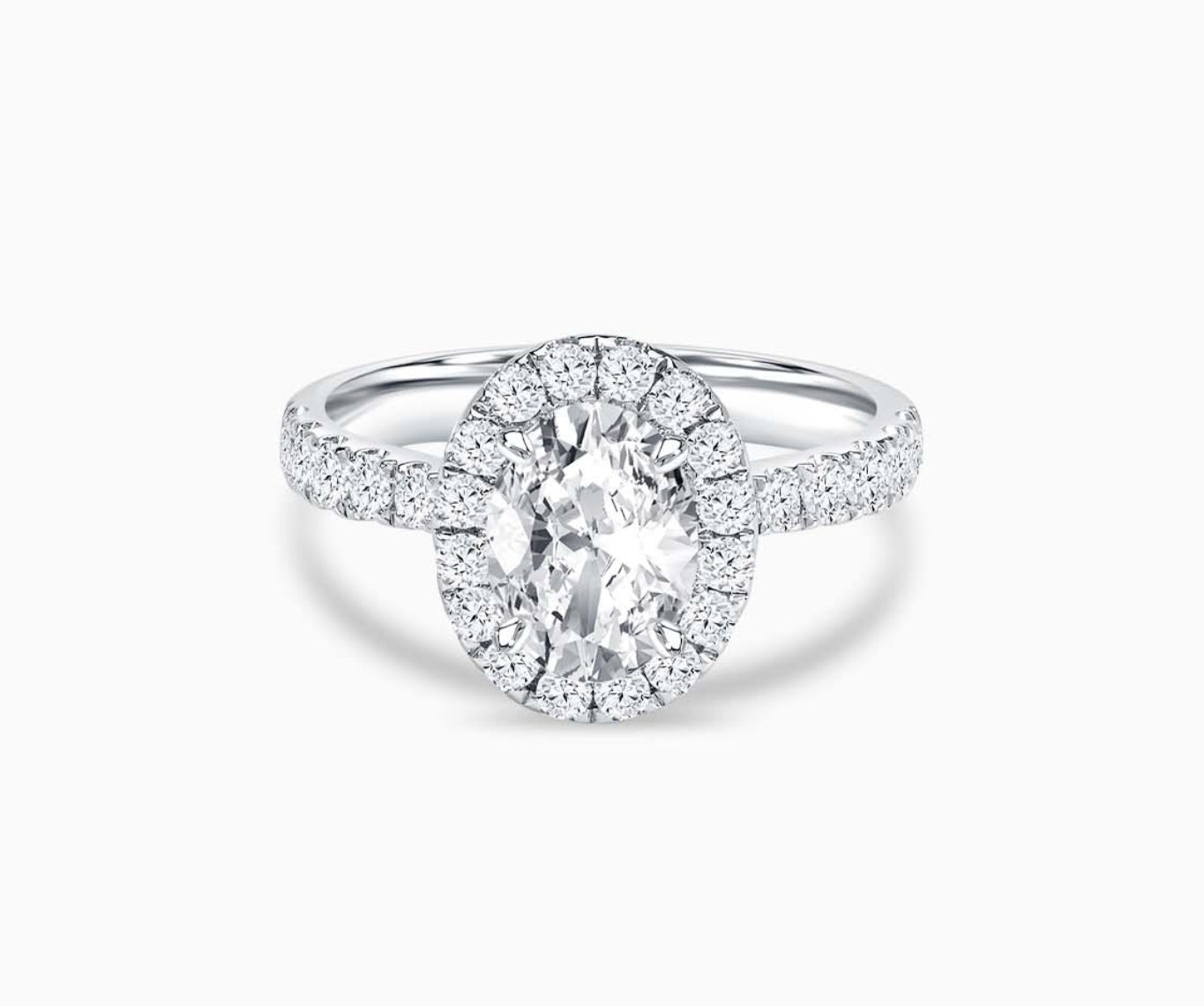 oval cut diamond halo engagement ring with a tapered pave white gold band 