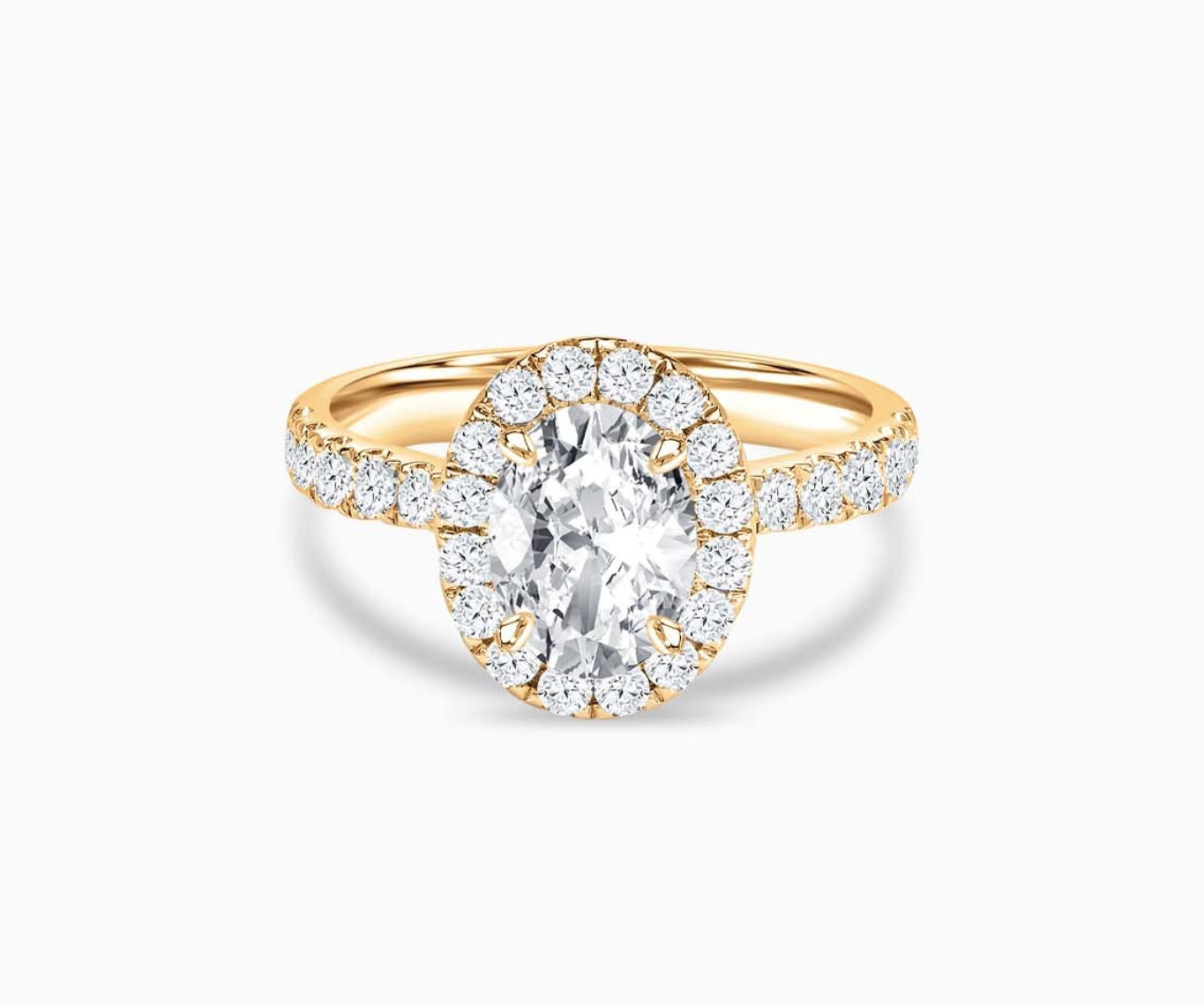 Oval cut diamond halo engagement ring set on yellow gold with a tapered pave band design