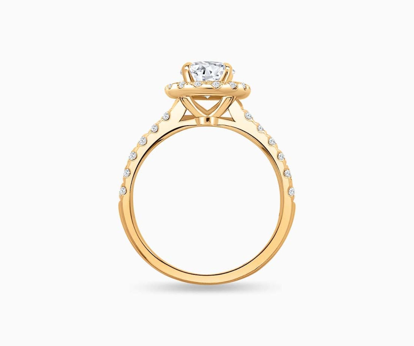 side view of Oval cut diamond halo engagement ring set on yellow gold with a tapered pave band design
