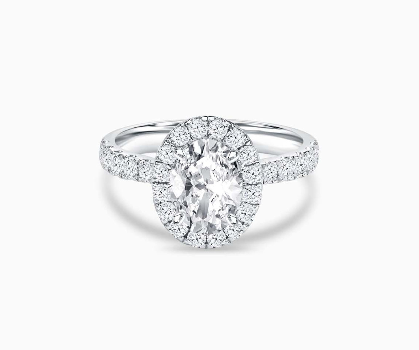 oval cut diamond halo engagement ring with a tapered straight pave white gold band 