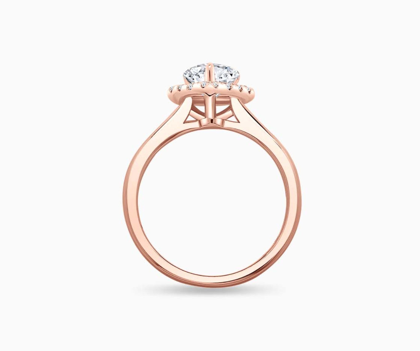 side view of pear shaped diamond halo engagement ring set in rose gold with a tapered plain band design
