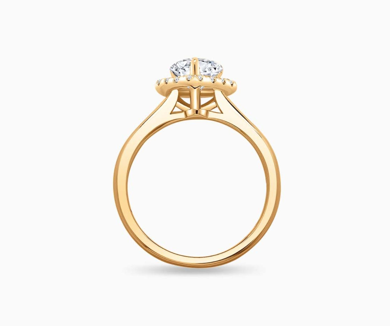 side view of Pear Shaped diamond halo engagement ring set on yellow gold with a tapered plain band design