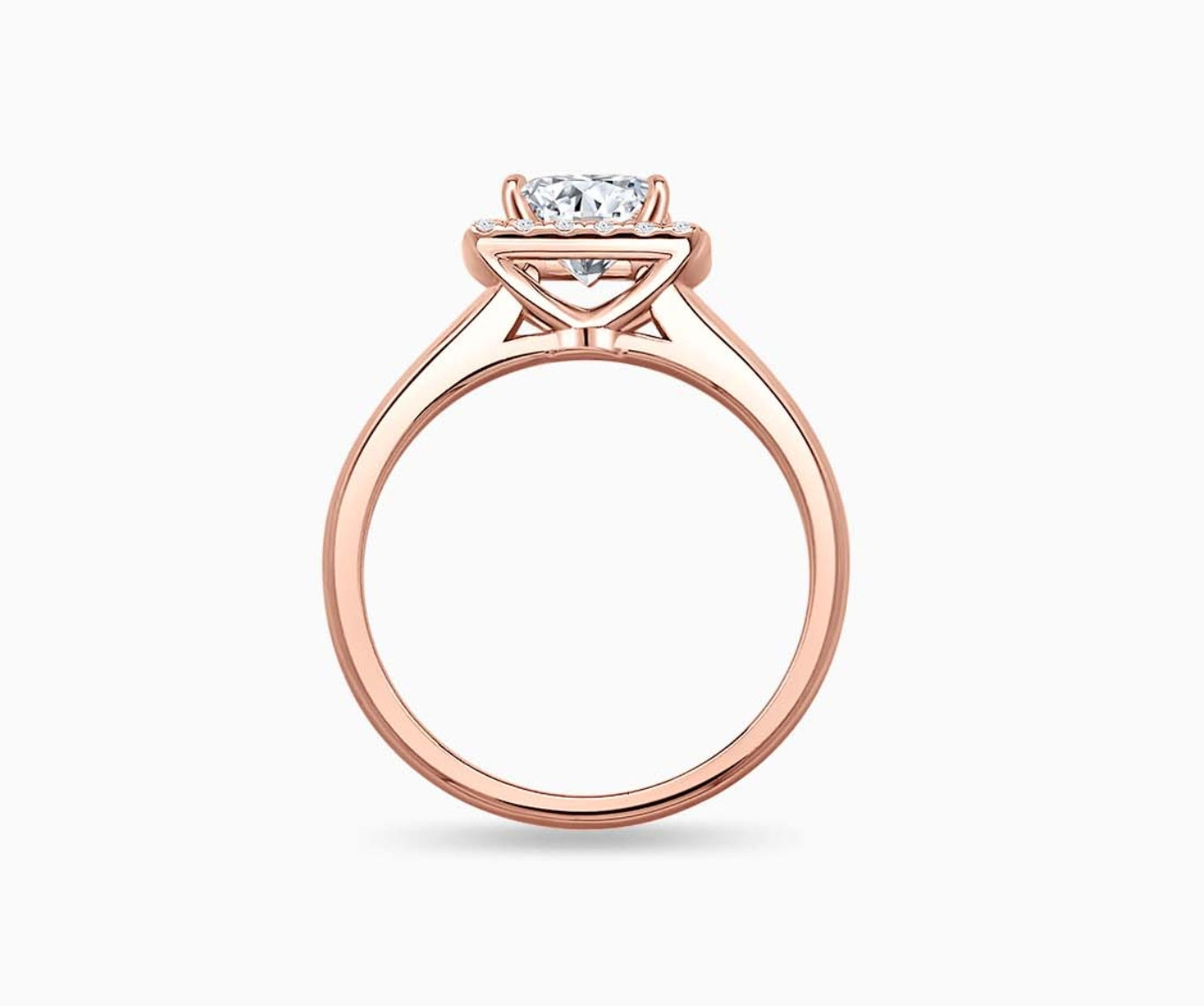 side view of emerald cut diamond halo engagement ring set in rose gold with straight plain band design