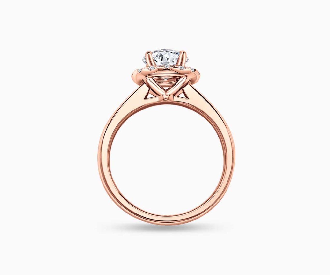 Side view of round diamond halo engagement ring set in rose gold with a straight plain band design