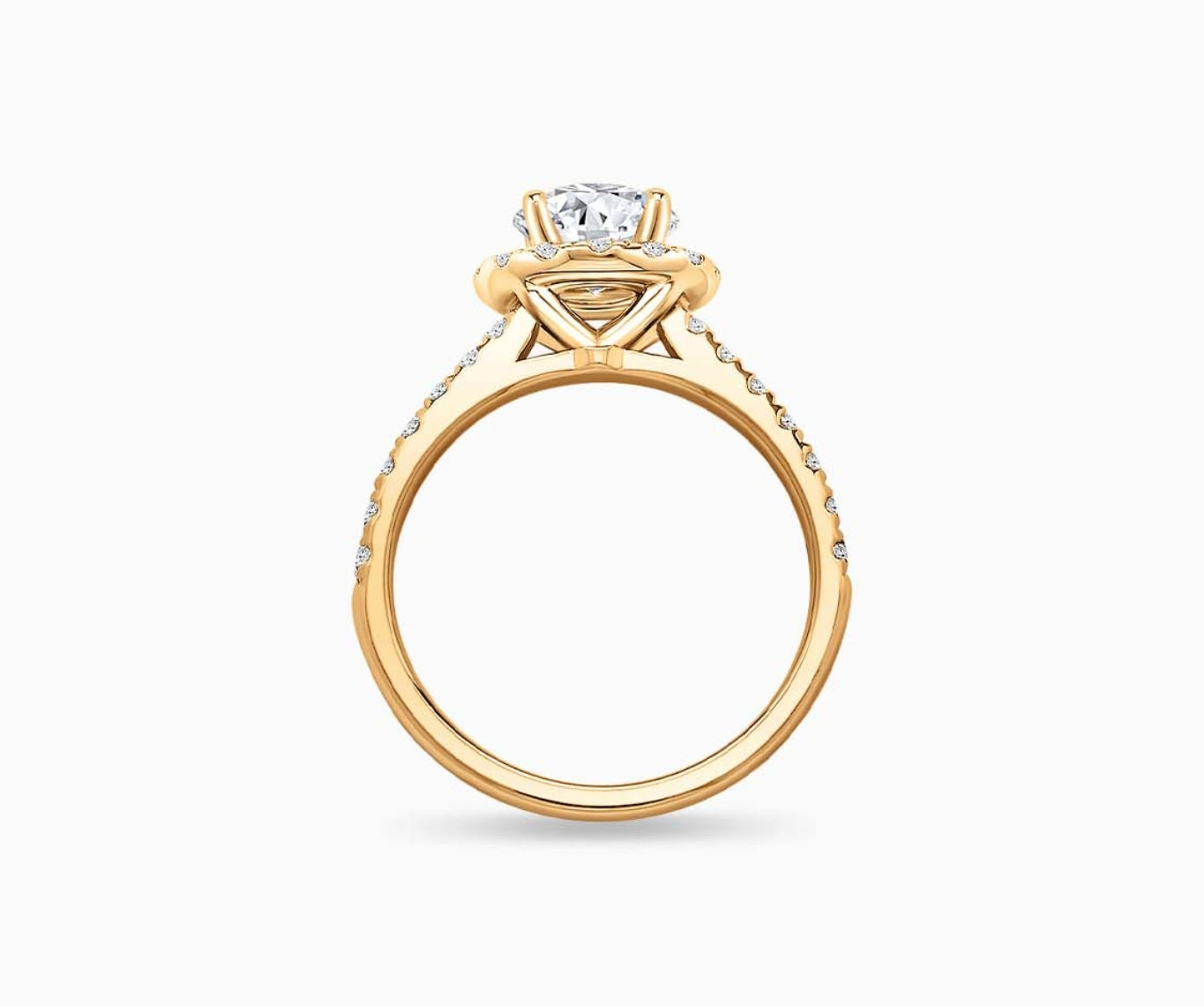 side view of Round cut diamond halo engagement ring set on yellow gold with a straight pave band design