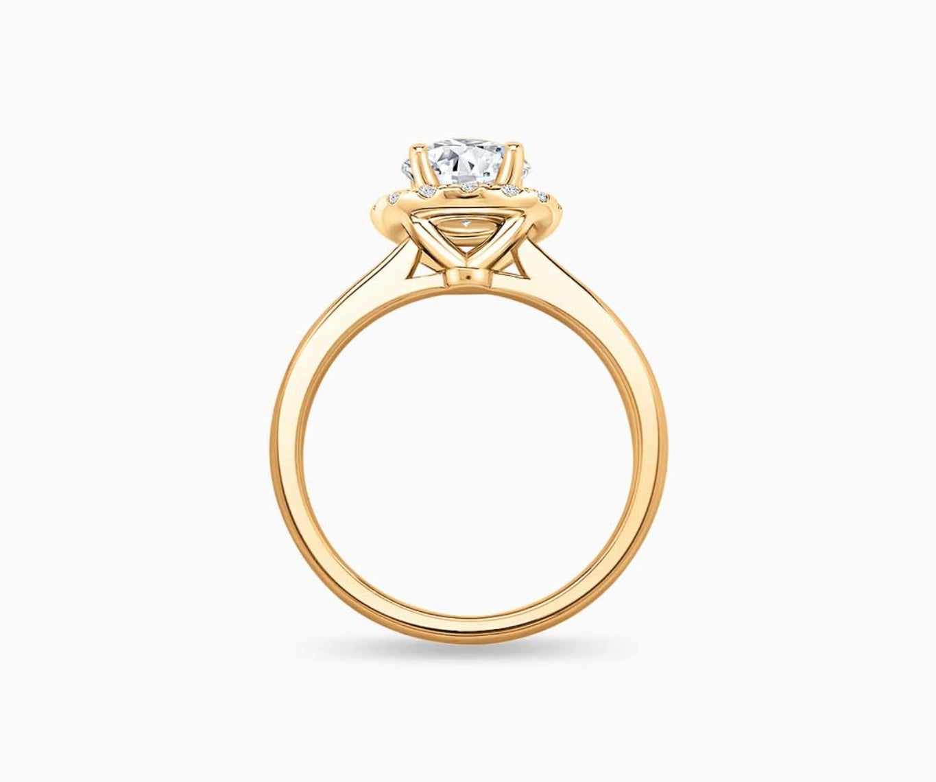 side view of Round cut diamond halo engagement ring set on yellow gold with a tapered plain band design