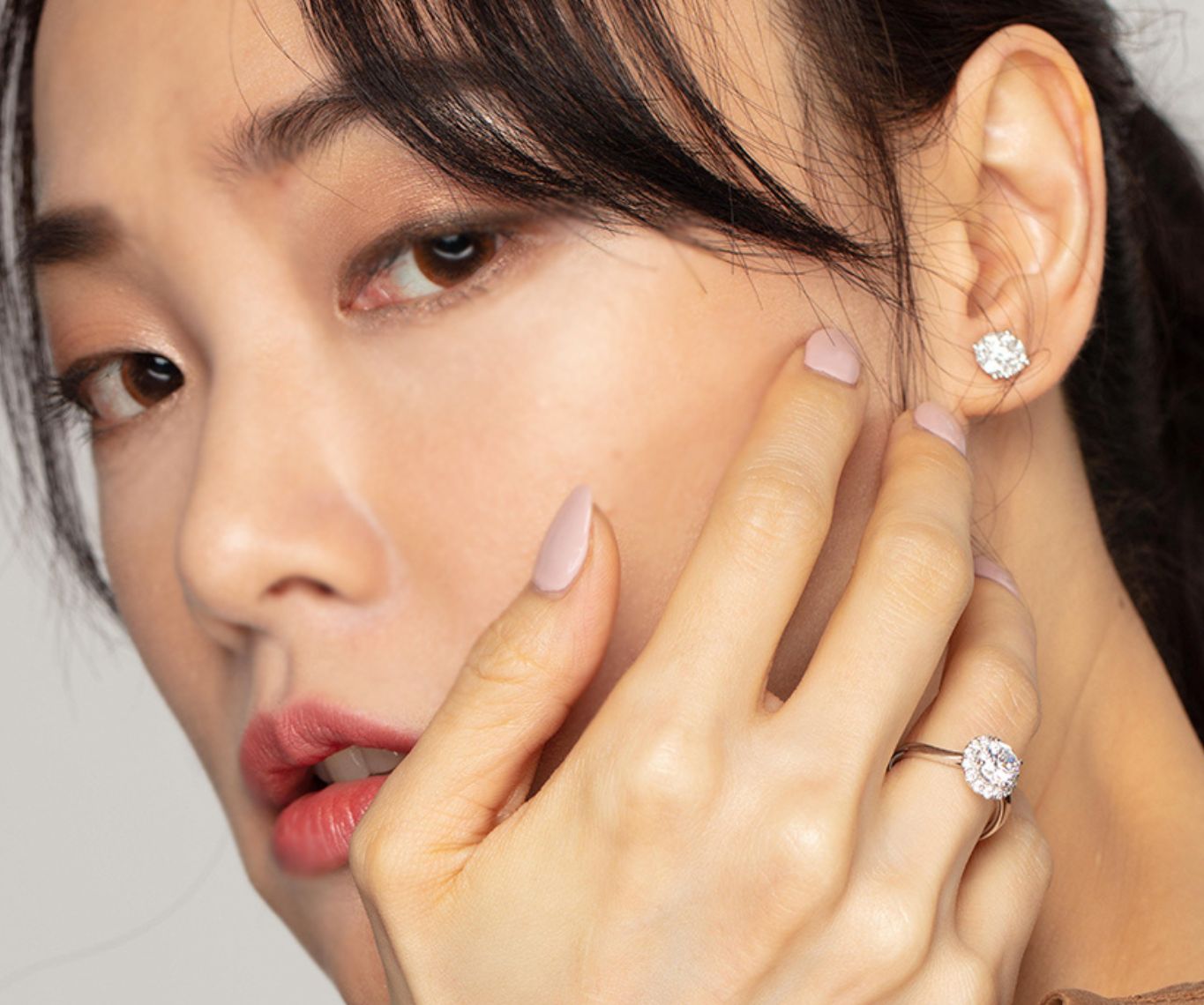 model wearing Halo Diamond Engagement Ring with tapered plain band and diamond earrings.