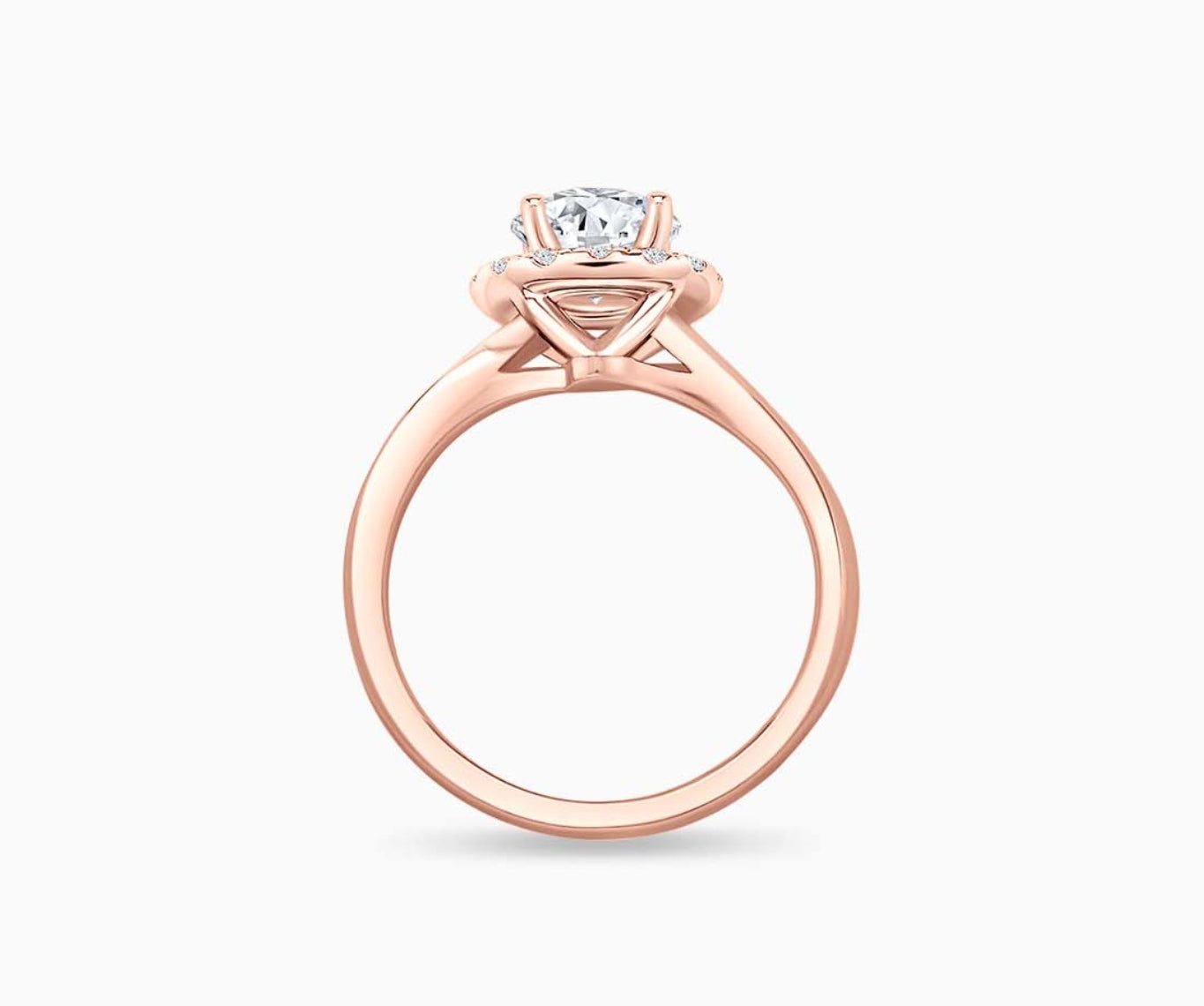 side view of round diamond halo engagement ring set in rose gold with a twirl plain band design