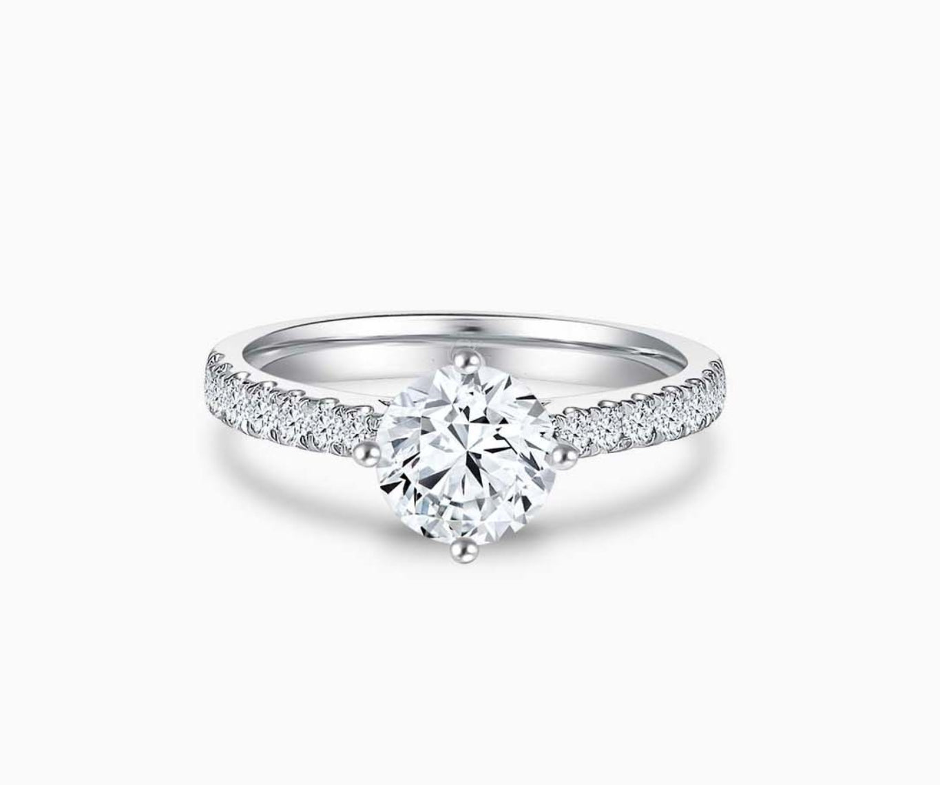 Elegant round-cut solitaire diamond ring with a straight pave white gold band, featuring a brilliant center stone secured by four prongs, accentuated by a row of dazzling smaller diamonds along the band for added sparkle.