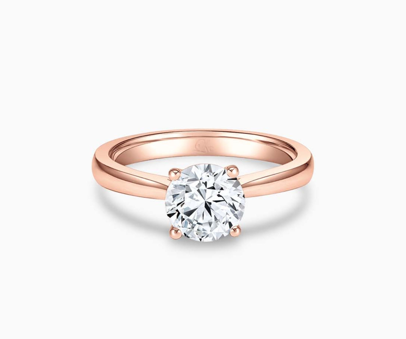 Rose gold solitaire diamond ring with a straight plain band that narrows towards the center stone, enhancing its brilliance and elegant appeal.