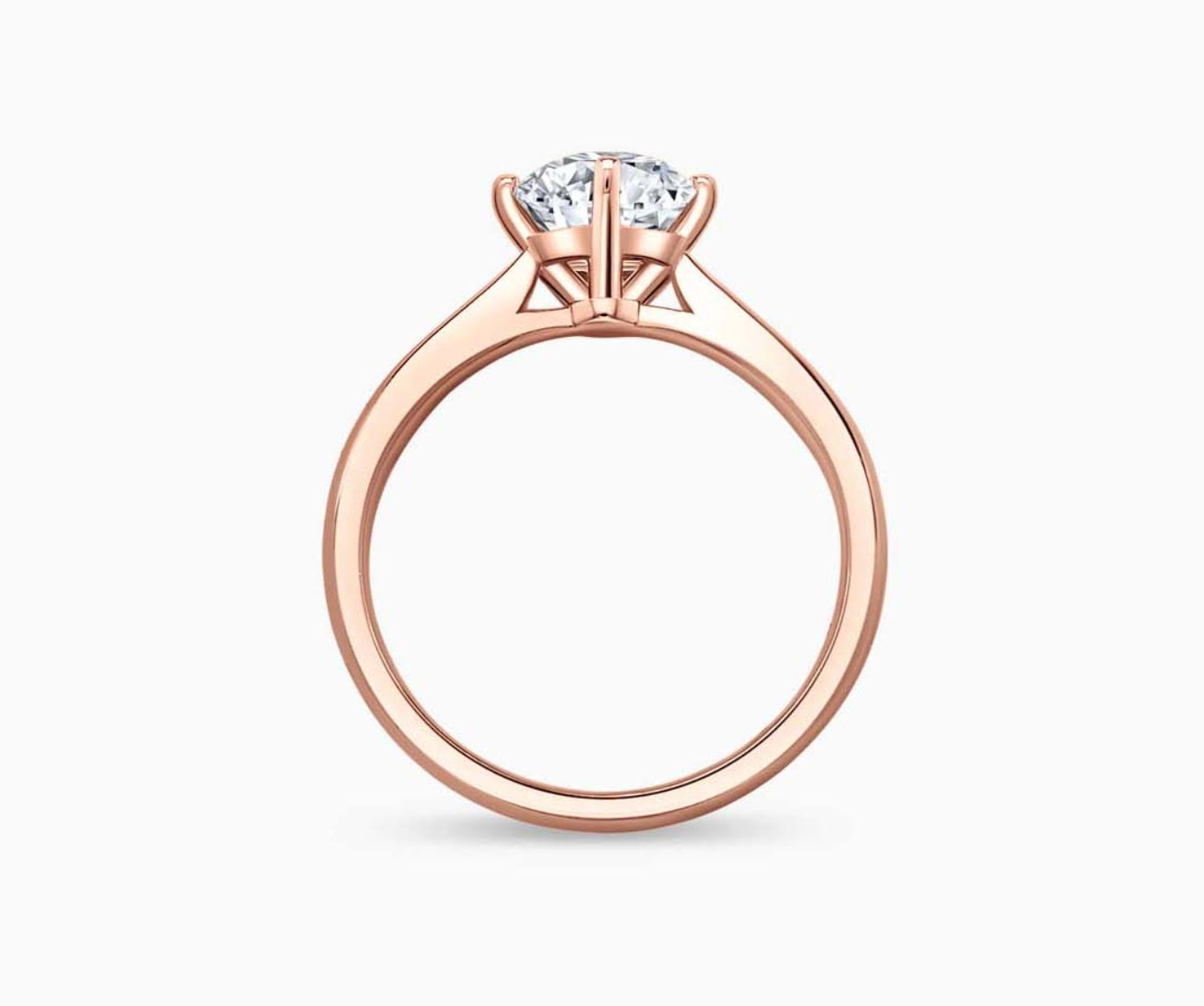 Rose gold solitaire diamond ring with a straight plain band that narrows towards the center stone, enhancing its brilliance and elegant appeal.