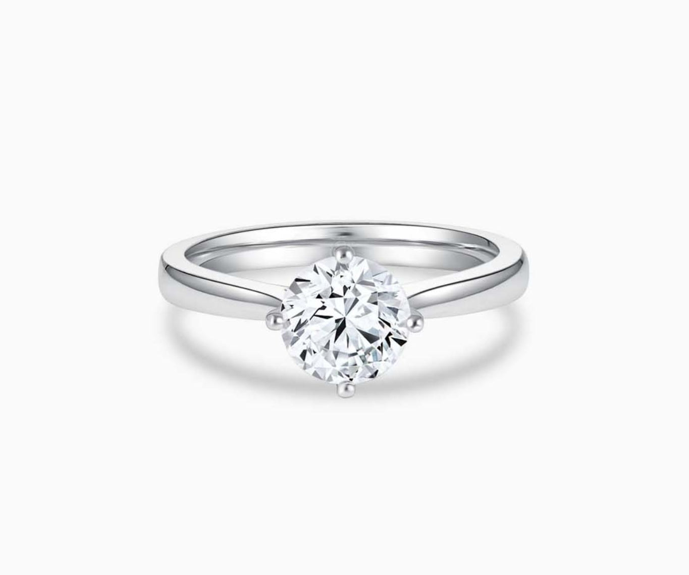 Solitaire diamond ring with a tapered white gold band that narrows towards the center stone, enhancing its brilliance and elegant appeal.