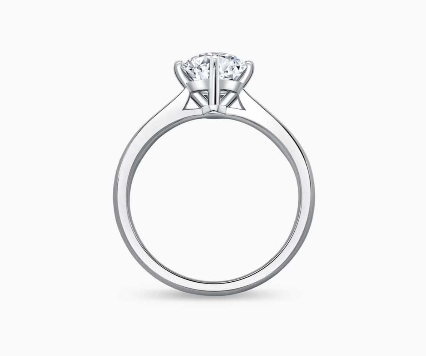Solitaire diamond ring with a tapered white gold band that narrows towards the center stone, enhancing its brilliance and elegant appeal.