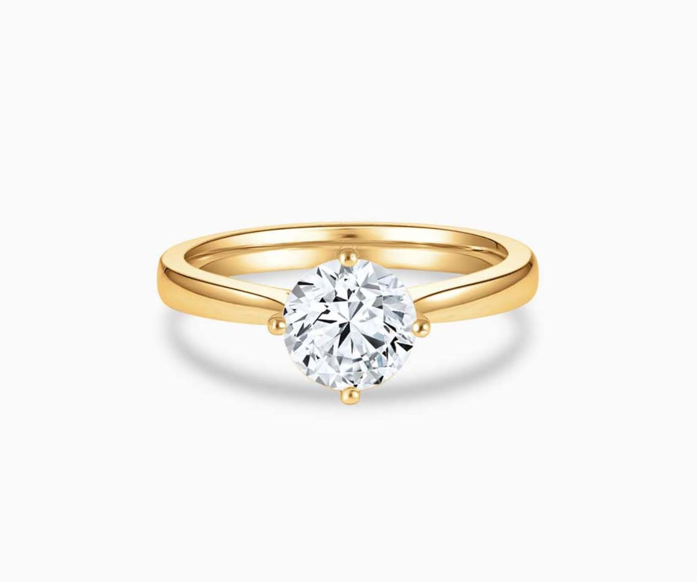 Yellow gold solitaire diamond ring with a tapered band that narrows towards the center stone, enhancing its brilliance and elegant appeal