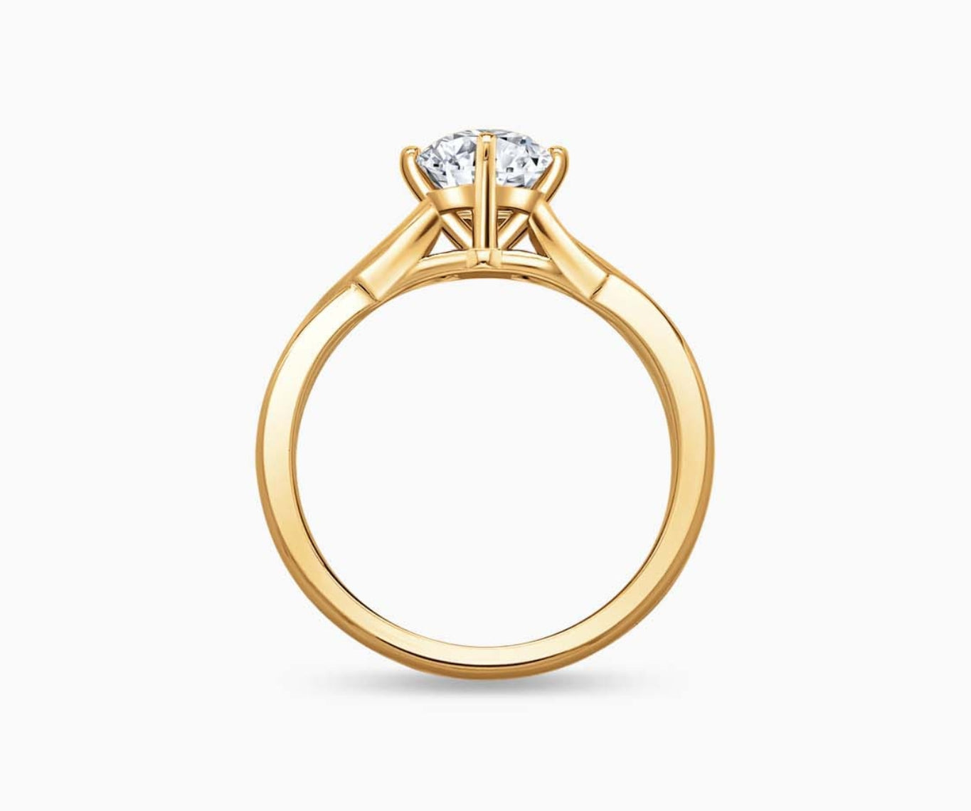 Yellow gold solitaire diamond ring with a twisted infinity band, symbolizing two entwining lives in a romantic and unique design.