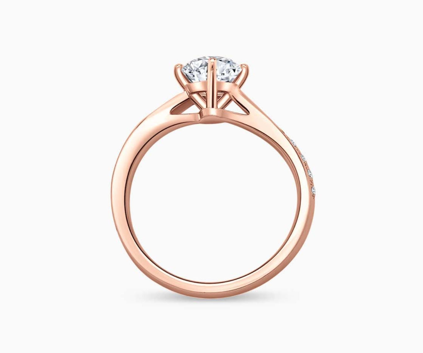 Rose gold solitaire diamond ring with a twirl band lined with side diamonds, blending vintage charm with modern elegance to highlight the center stone.