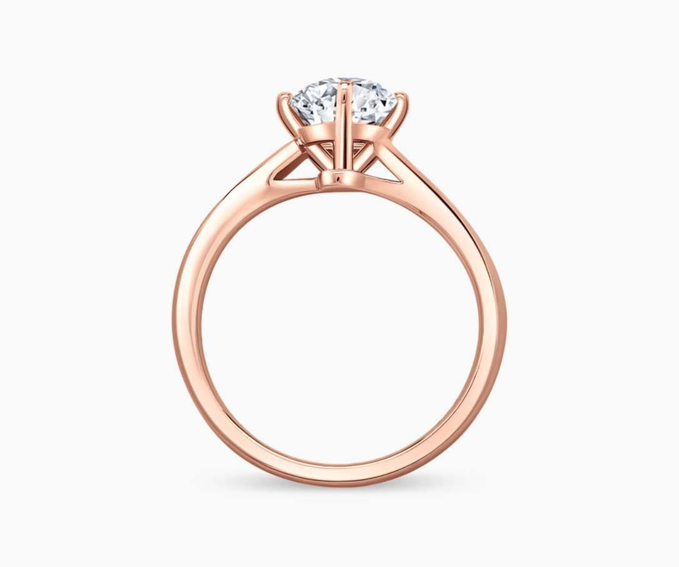 Rose gold solitaire diamond ring with a sleek twirl band, blending vintage charm with modern elegance to highlight the center stone.