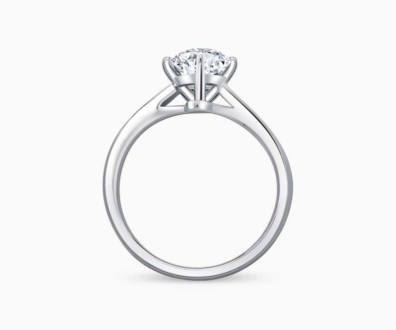 Solitaire diamond ring with a sleek twirl band in white gold, blending vintage charm with modern elegance to accentuate the center stone.