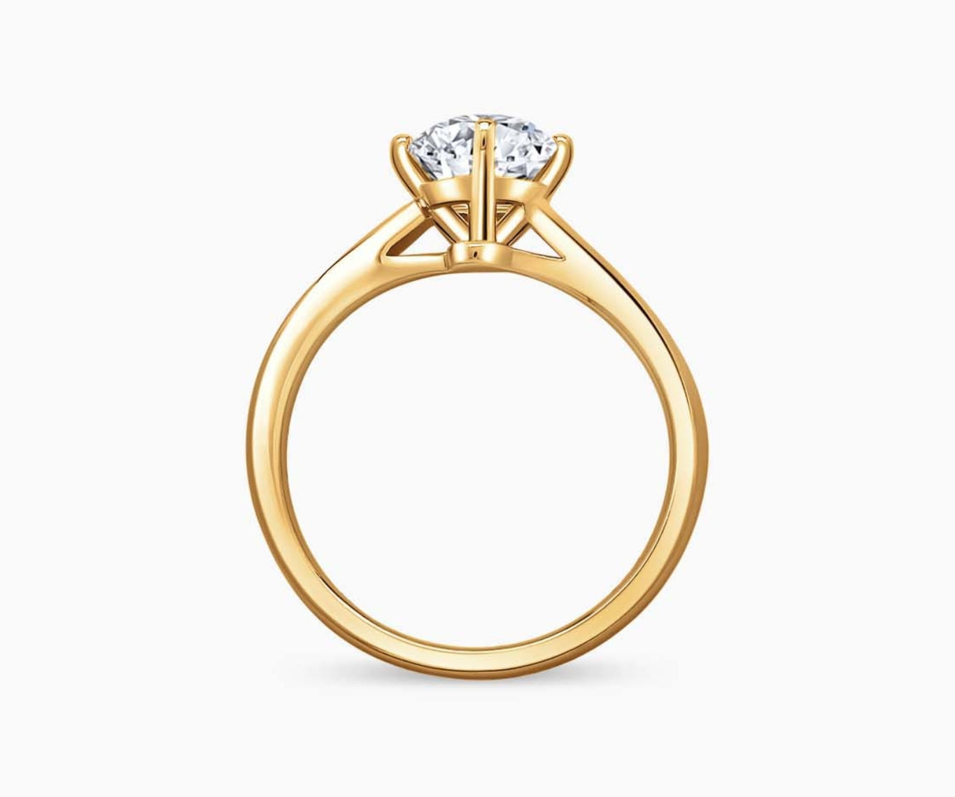 Yellow gold solitaire diamond ring with a sleek twirl band, blending vintage charm with modern elegance to highlight the center stone